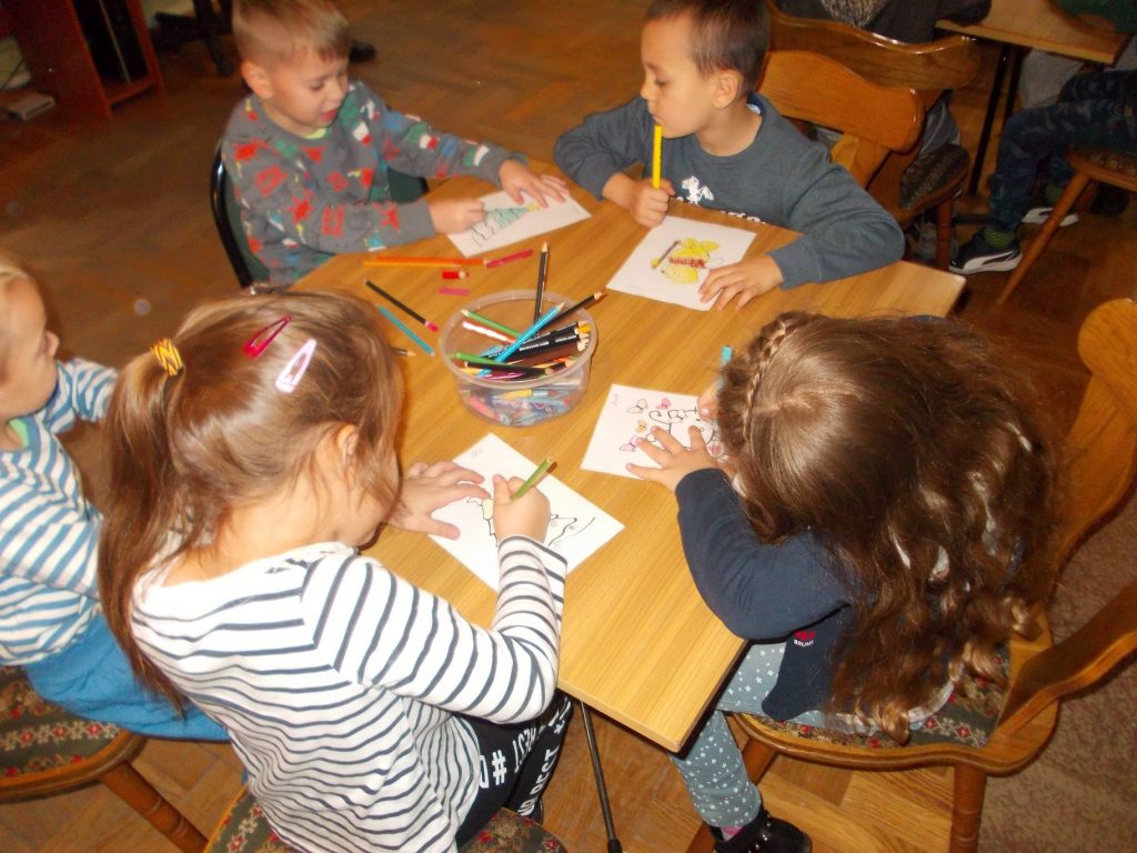 dzieci malują kredkami